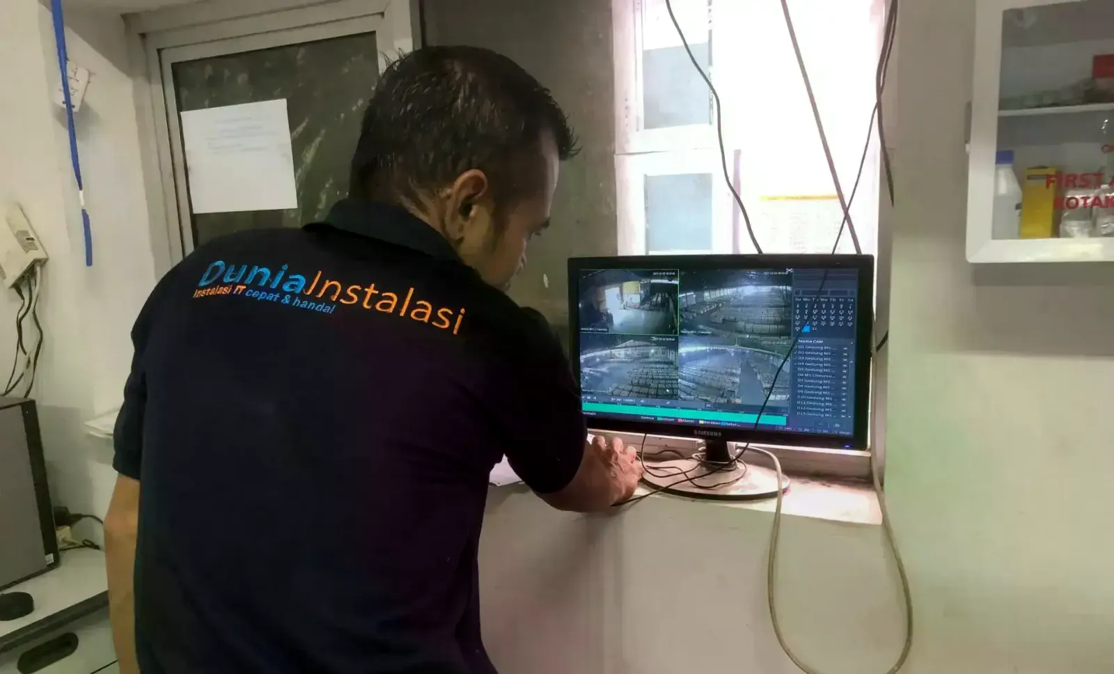 Teknisi mengatur tampilan NVR multi-kamera