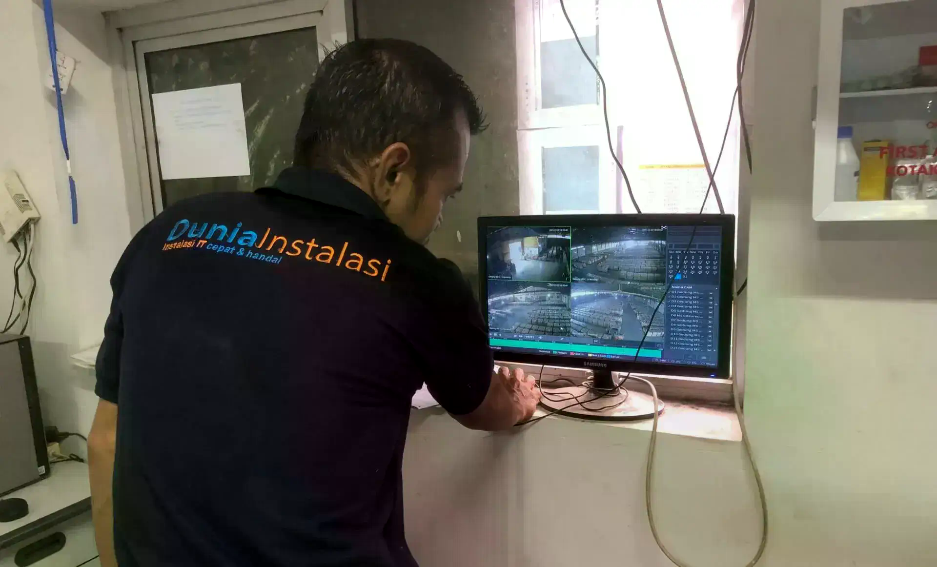 Teknisi mengatur tampilan NVR multi-kamera