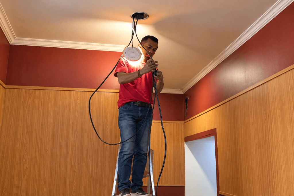 Teknisi Dunia Instalasi memasang akses point WiFi di Hungrypedia