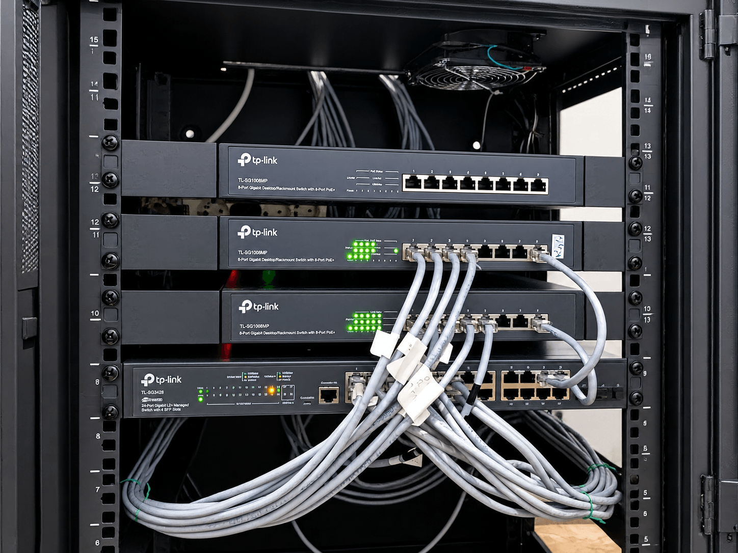 Switch jaringan dan patch kabel yang tertata rapi di dalam rack