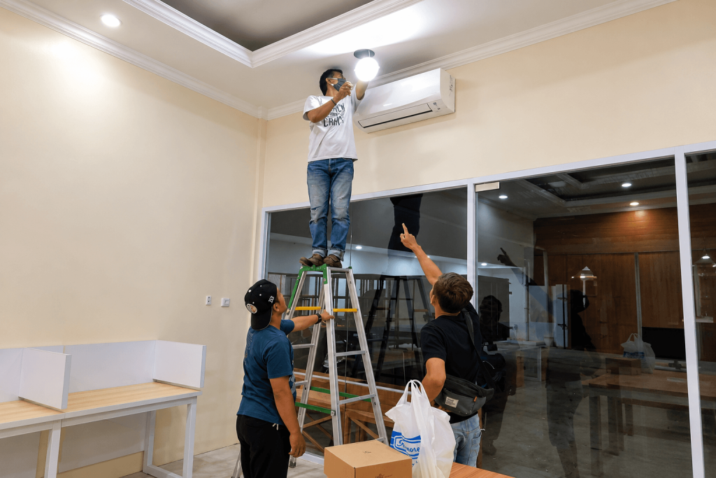 Tim Dunia Instalasi memasang akses point WiFi di plafon kantor