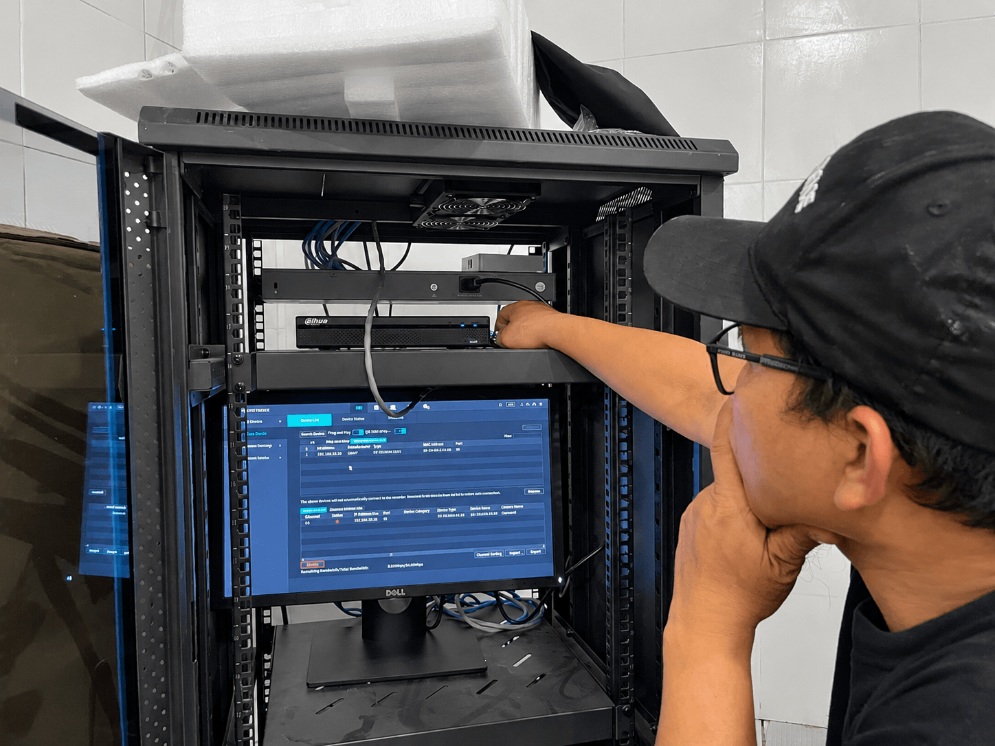Teknisi Dunia Instalasi mengonfigurasi NVR CCTV di dalam rack
