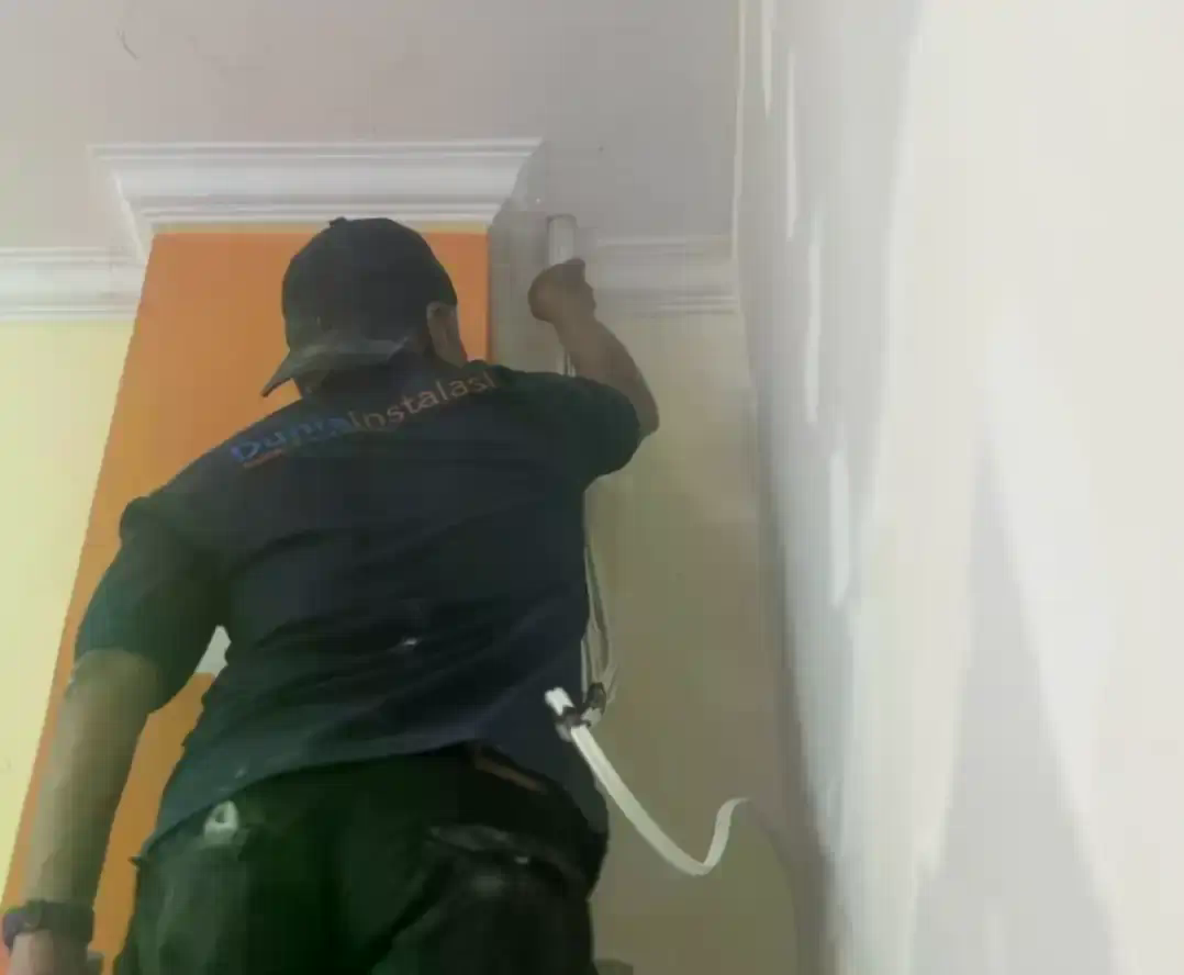 Teknisi merapikan kabel di rack jaringan